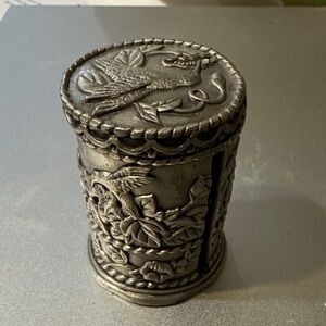 Ornate pewter stamp roll holder has a hummingbirds design